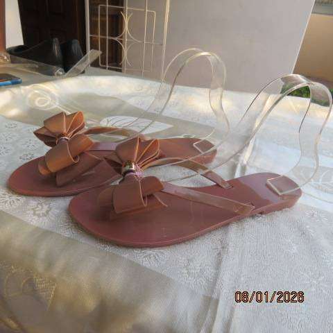 Pair of brownish pink flat sandals in bendable plastic with pretty bow. Size 8