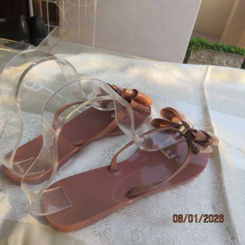 Pair of brownish pink flat sandals in bendable plastic with pretty bow. Size 8