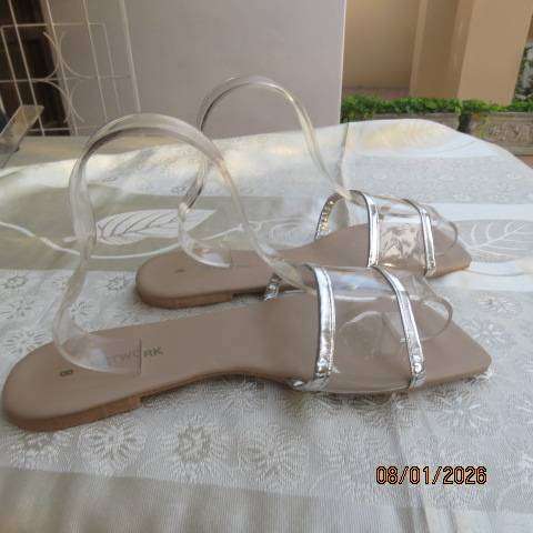 Pair of flip flop sandals with clear band with silver over foot. Never worn. Size 8