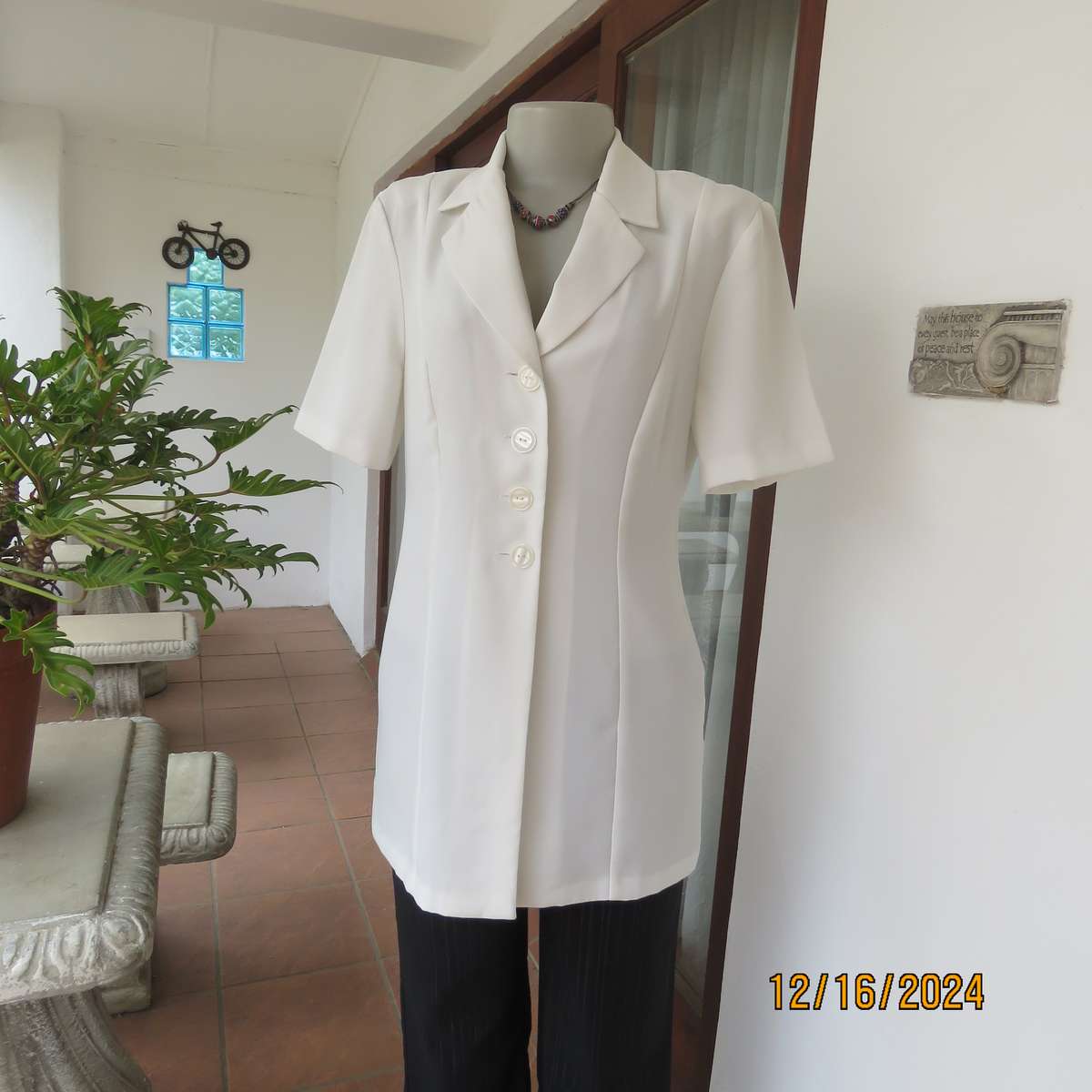 Elegant light cream tailored jacket closing with 4 front buttons. Collar and short sleeves.Size 34