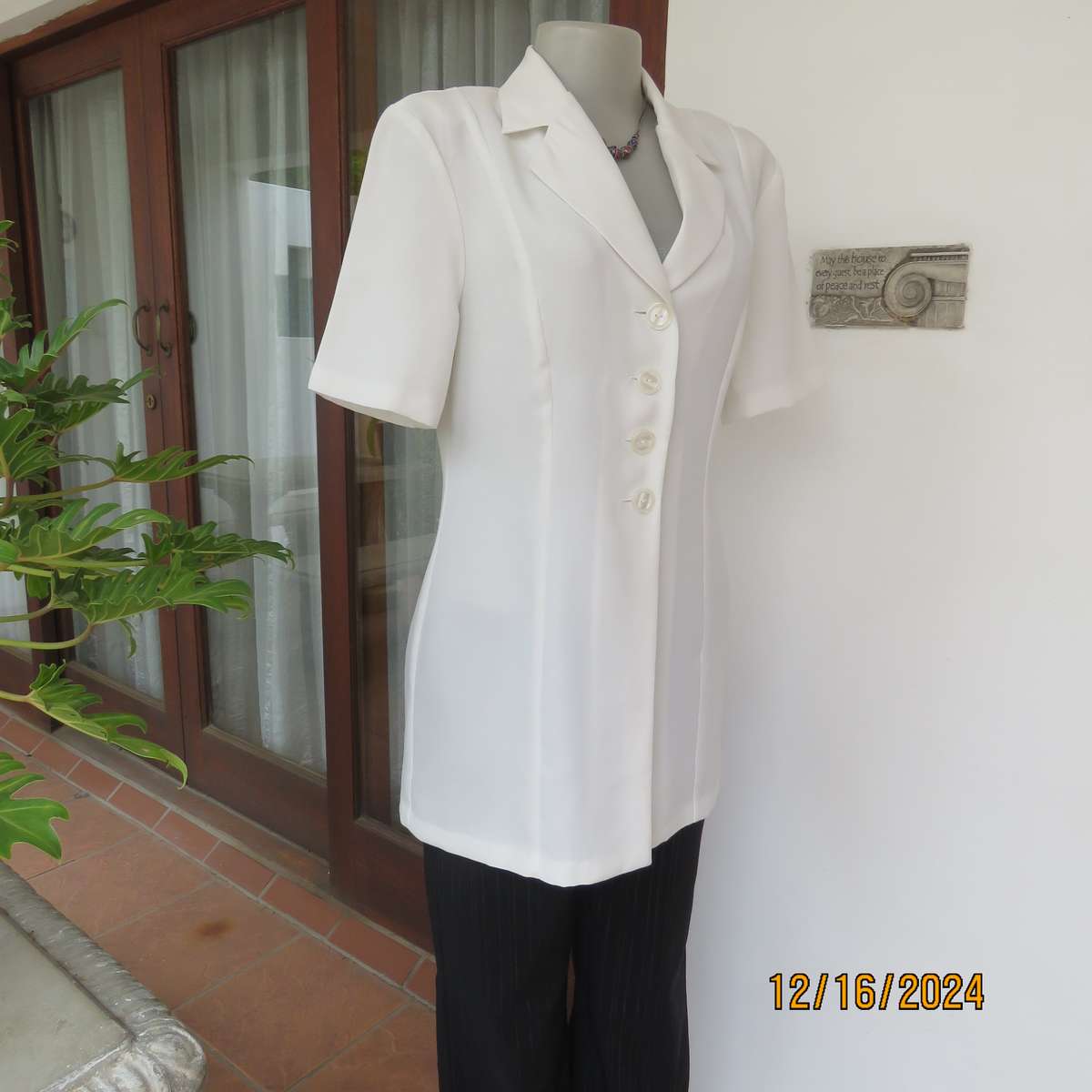 Elegant light cream tailored jacket closing with 4 front buttons. Collar and short sleeves.Size 34