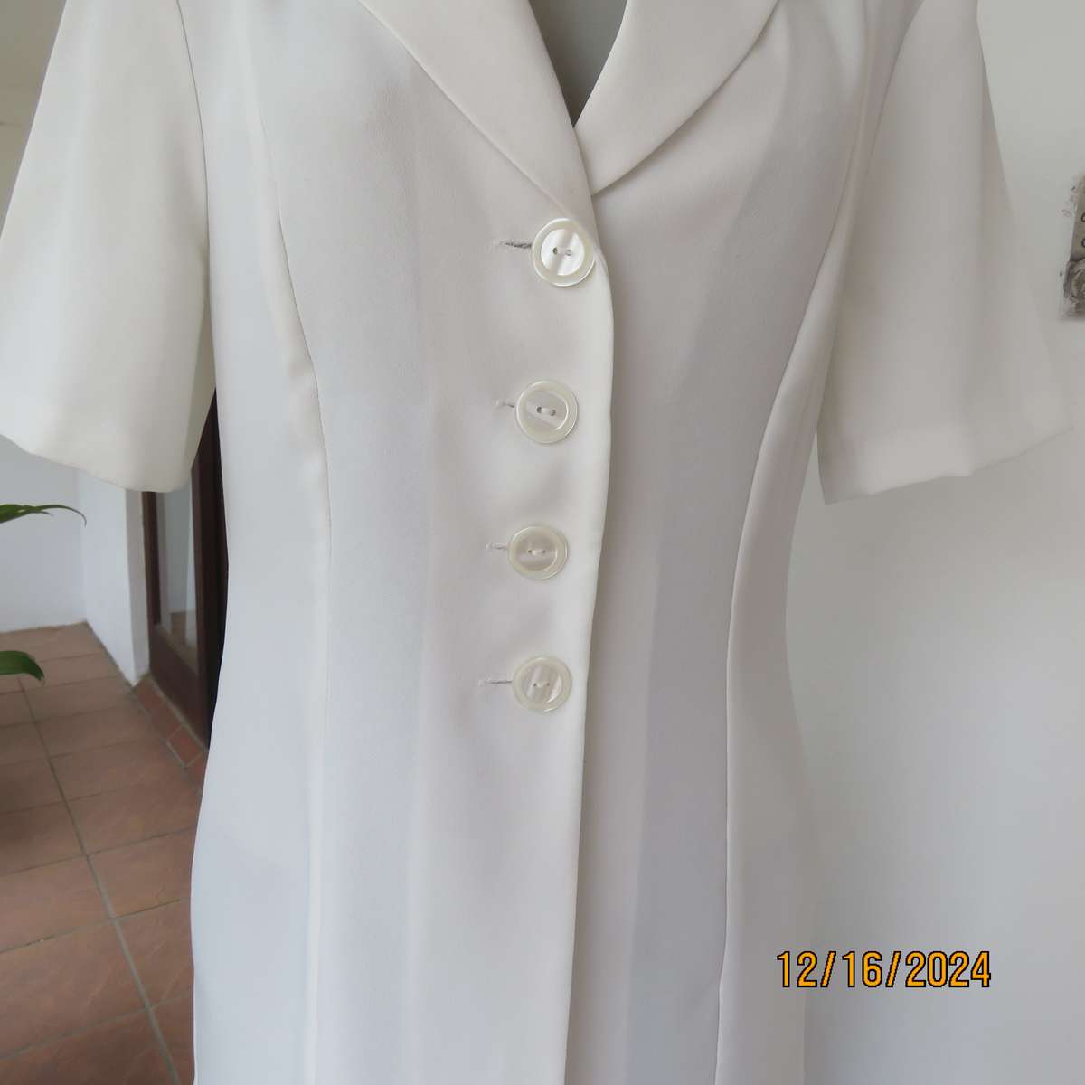 Elegant light cream tailored jacket closing with 4 front buttons. Collar and short sleeves.Size 34