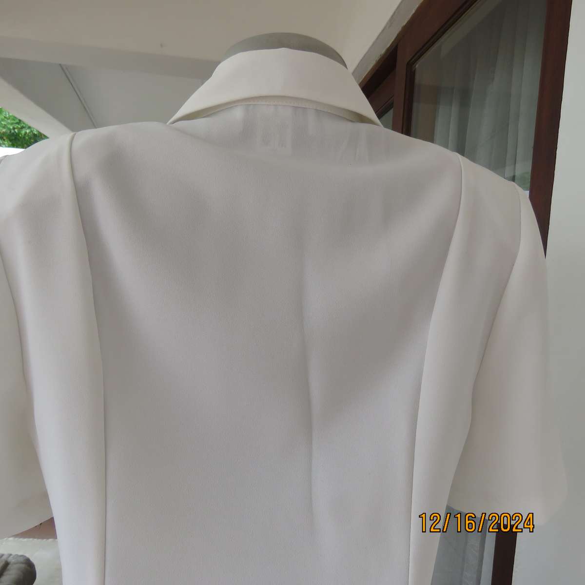 Elegant light cream tailored jacket closing with 4 front buttons. Collar and short sleeves.Size 34