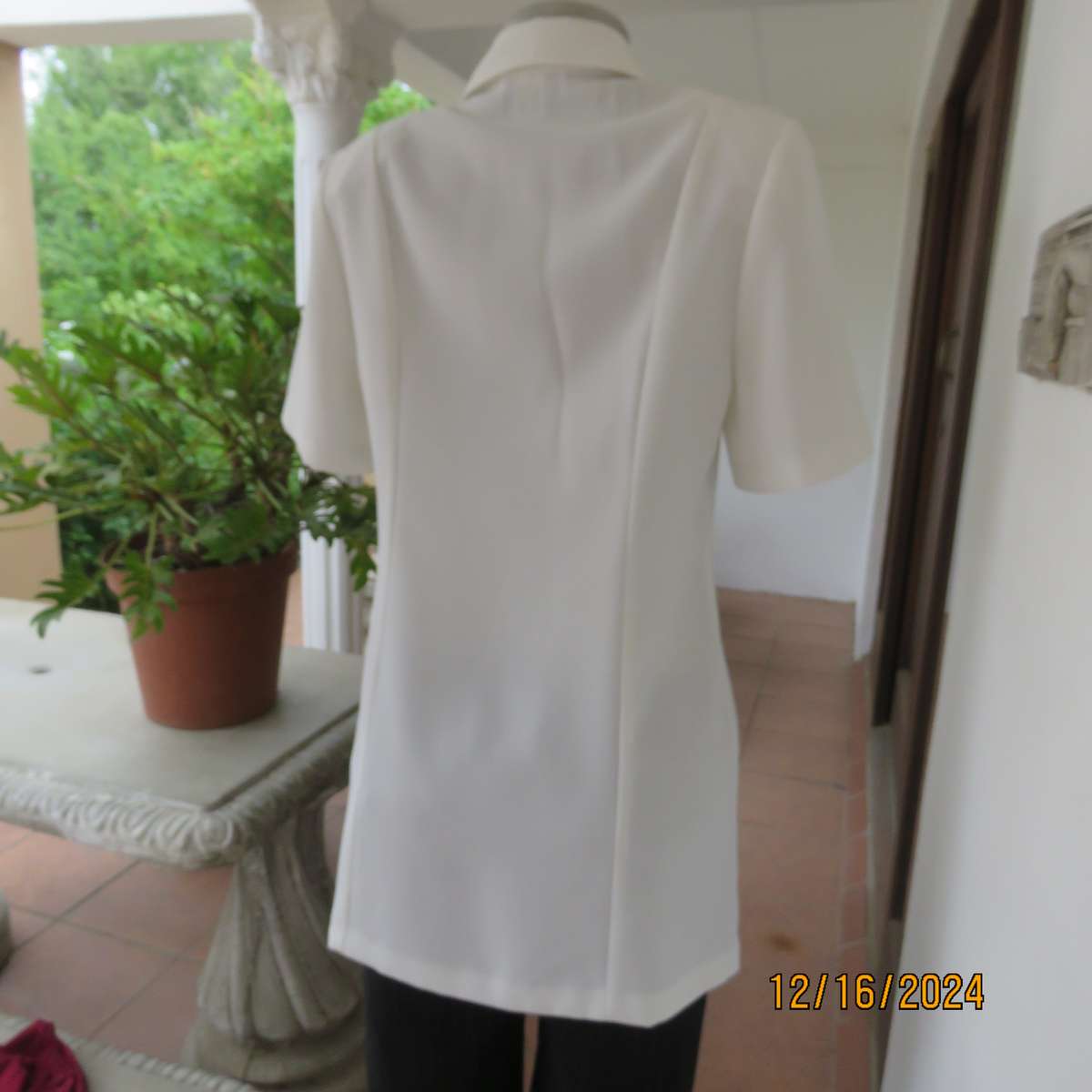 Elegant light cream tailored jacket closing with 4 front buttons. Collar and short sleeves.Size 34