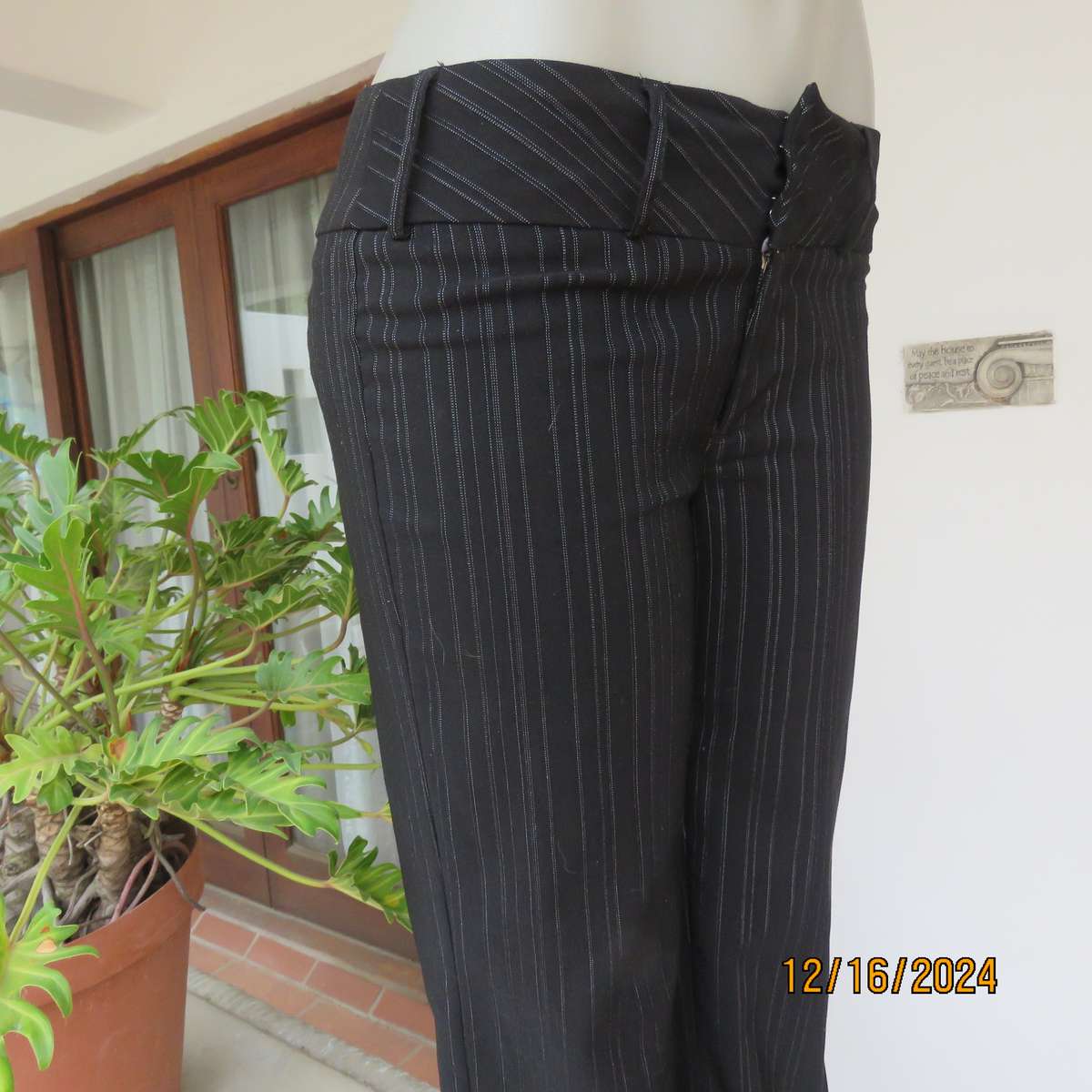Black pinstripe bootlegged polyester-rayon stretch pants size 34. Dummy pockets at back. As new con.