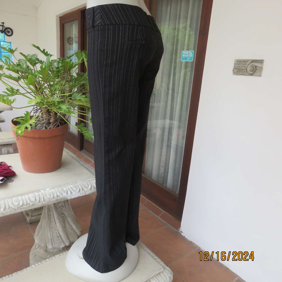 Black pinstripe bootlegged polyester-rayon stretch pants size 34. Dummy pockets at back. As new con.