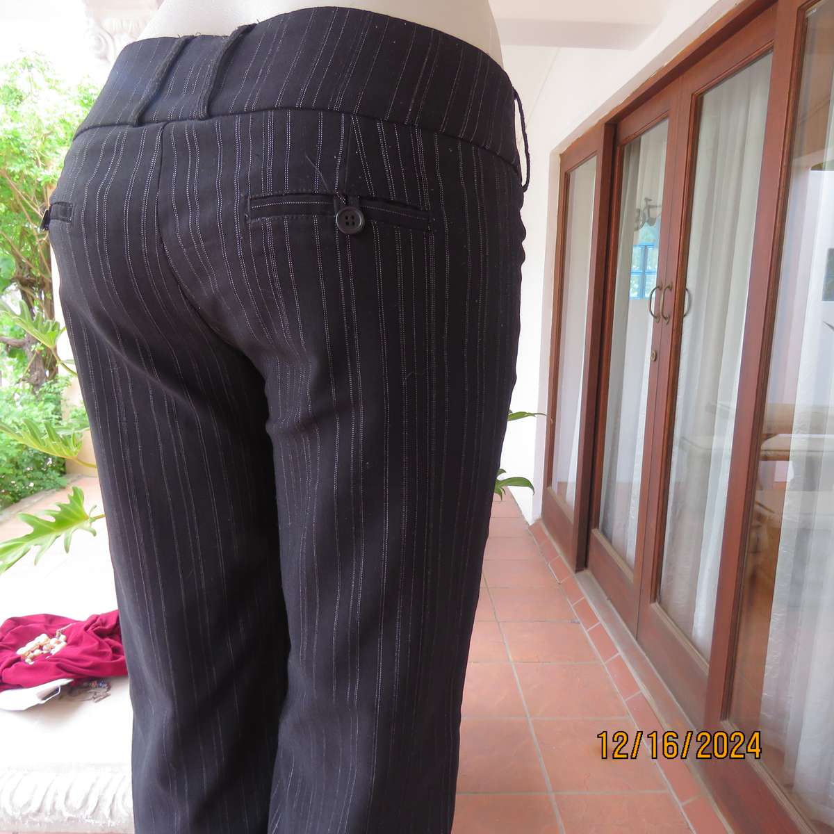 Black pinstripe bootlegged polyester-rayon stretch pants size 34. Dummy pockets at back. As new con.