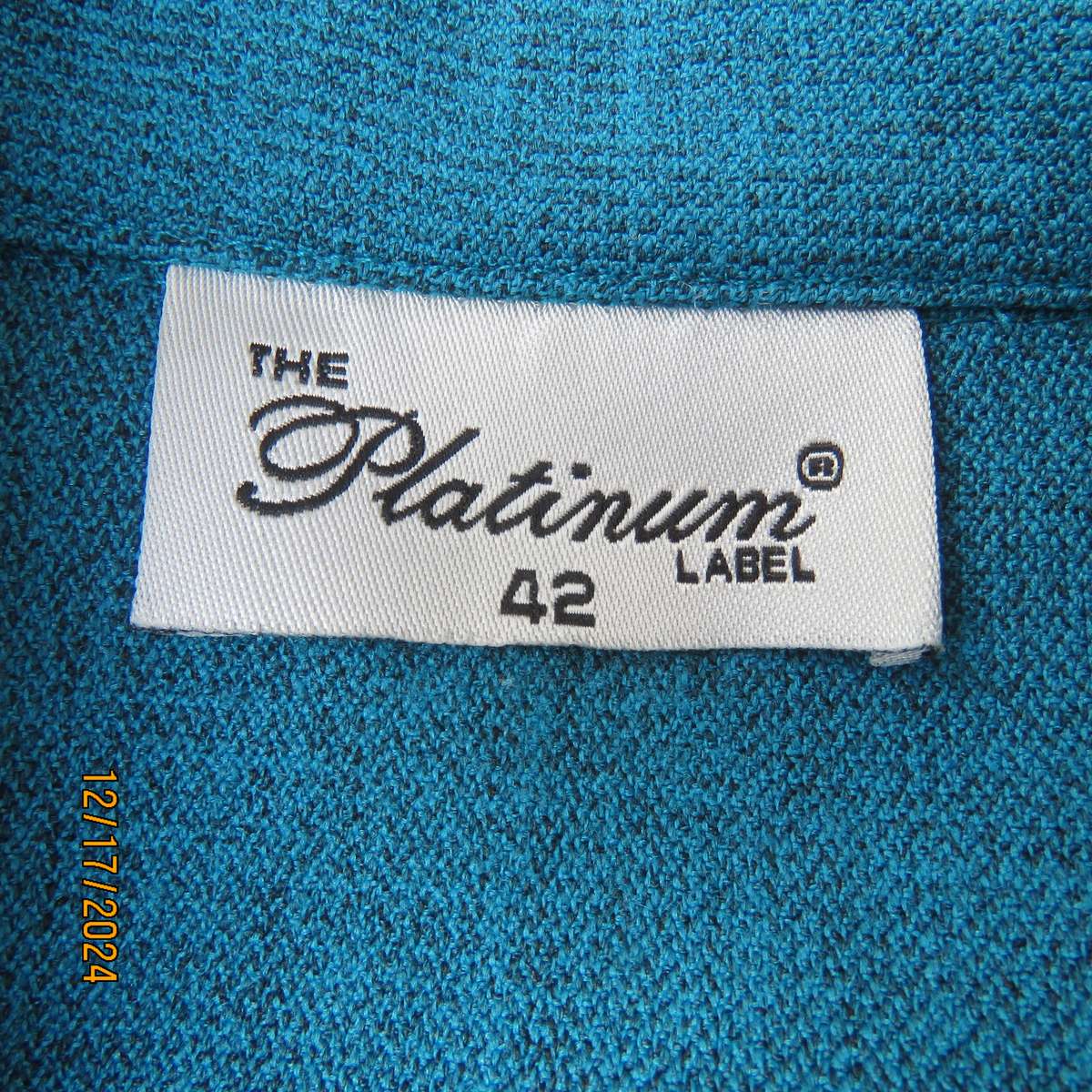 State of the art blue jade -black mottled polyester jacket.Criss-cross black decoration.Size 42.