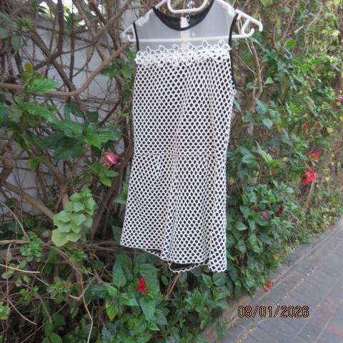 Girls black stretch polyester short jumpsuit with cream mesh overlay. For 13-14 yr old.