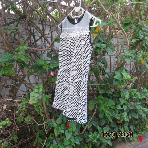 Girls black stretch polyester short jumpsuit with cream mesh overlay. For 13-14 yr old.