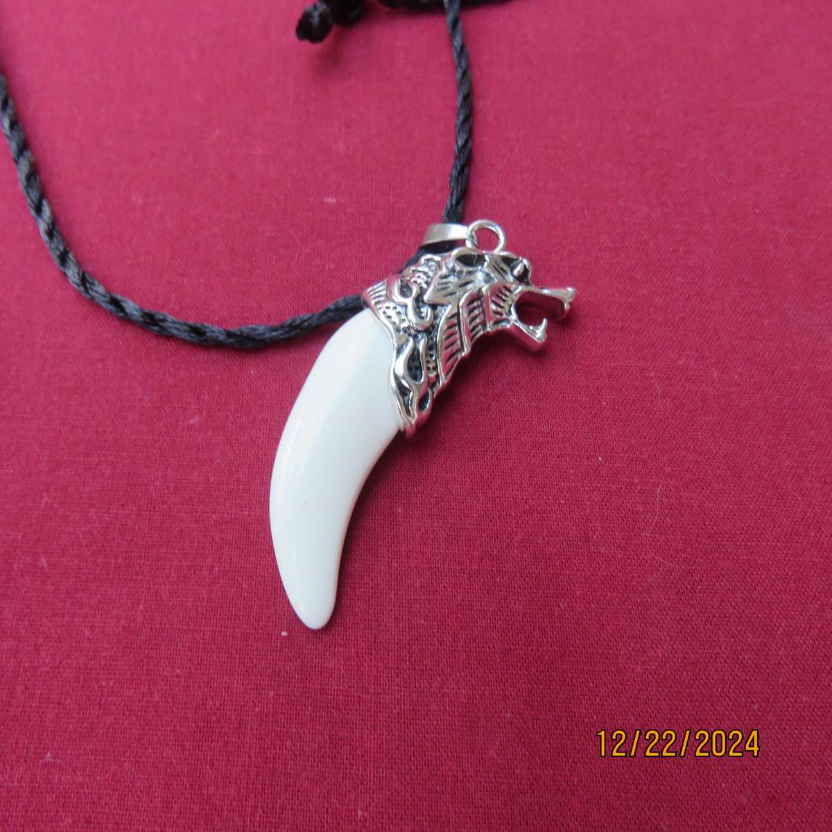 Faux tooth pendant in stainless steel with black cord