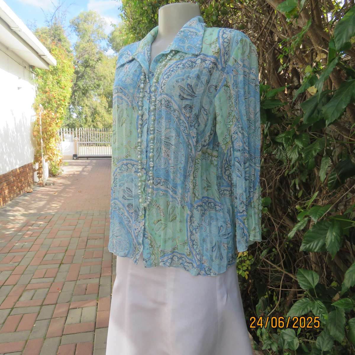 Soft blue-green permanent pleated paisley printed polyester top. Size 38.
