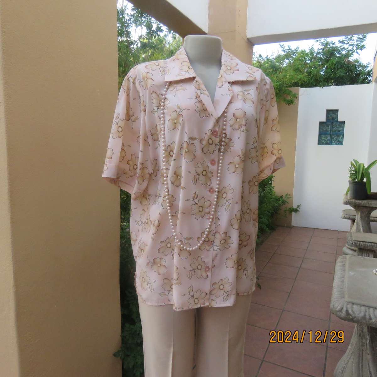 Tastefully printed flowers on pale peach background silky polyester short sleeve top.Size 40. As new