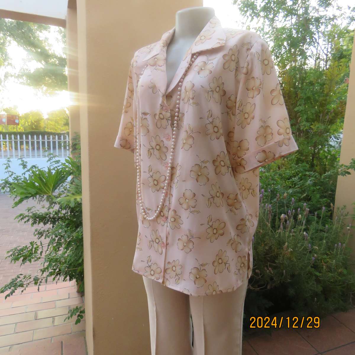 Tastefully printed flowers on pale peach background silky polyester short sleeve top.Size 40. As new