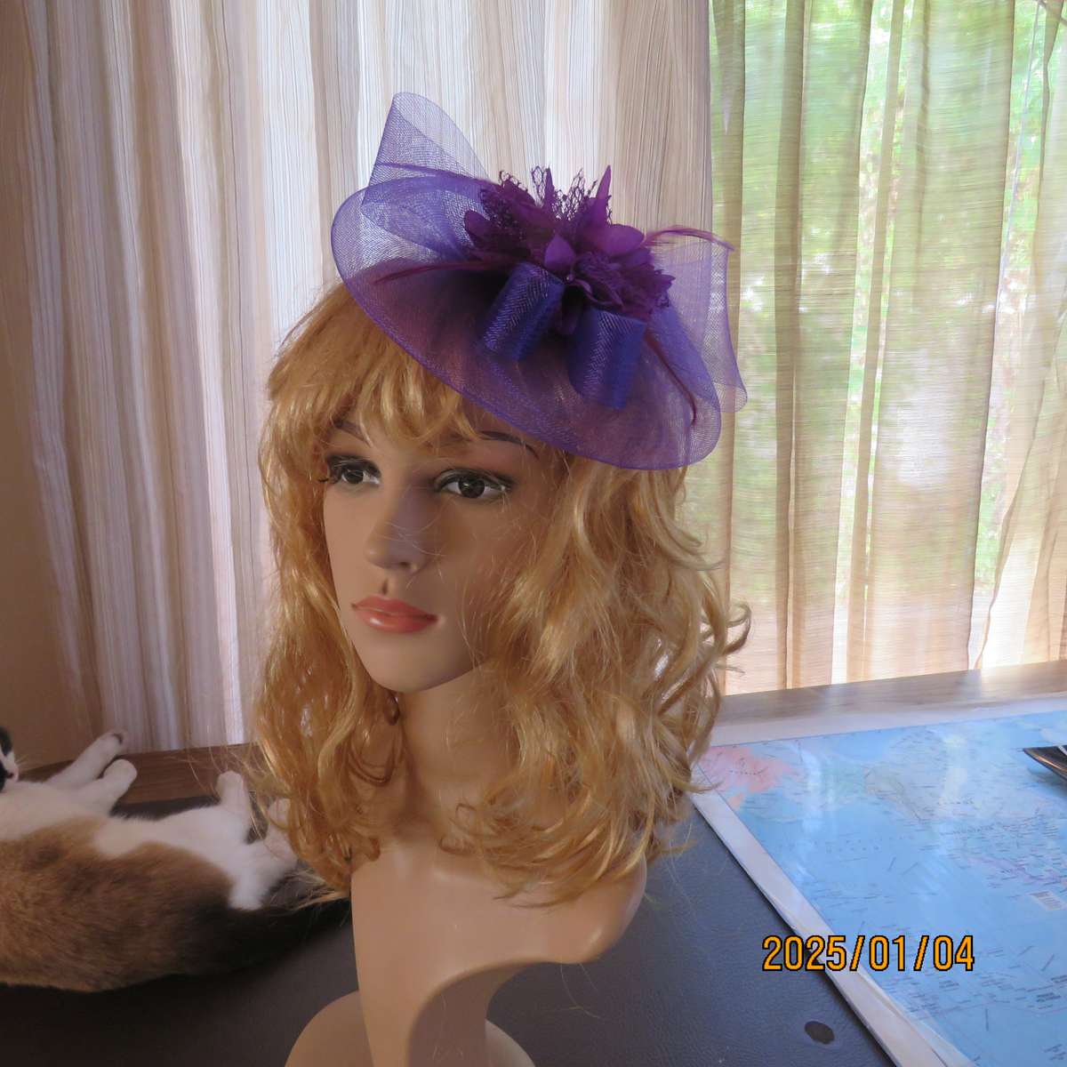 Dainty purple fascinator hat for special occasion. In mesh with bow-flower and feathers. Alice band