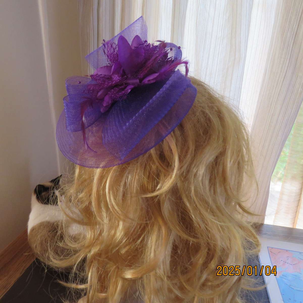 Dainty purple fascinator hat for special occasion. In mesh with bow-flower and feathers. Alice band