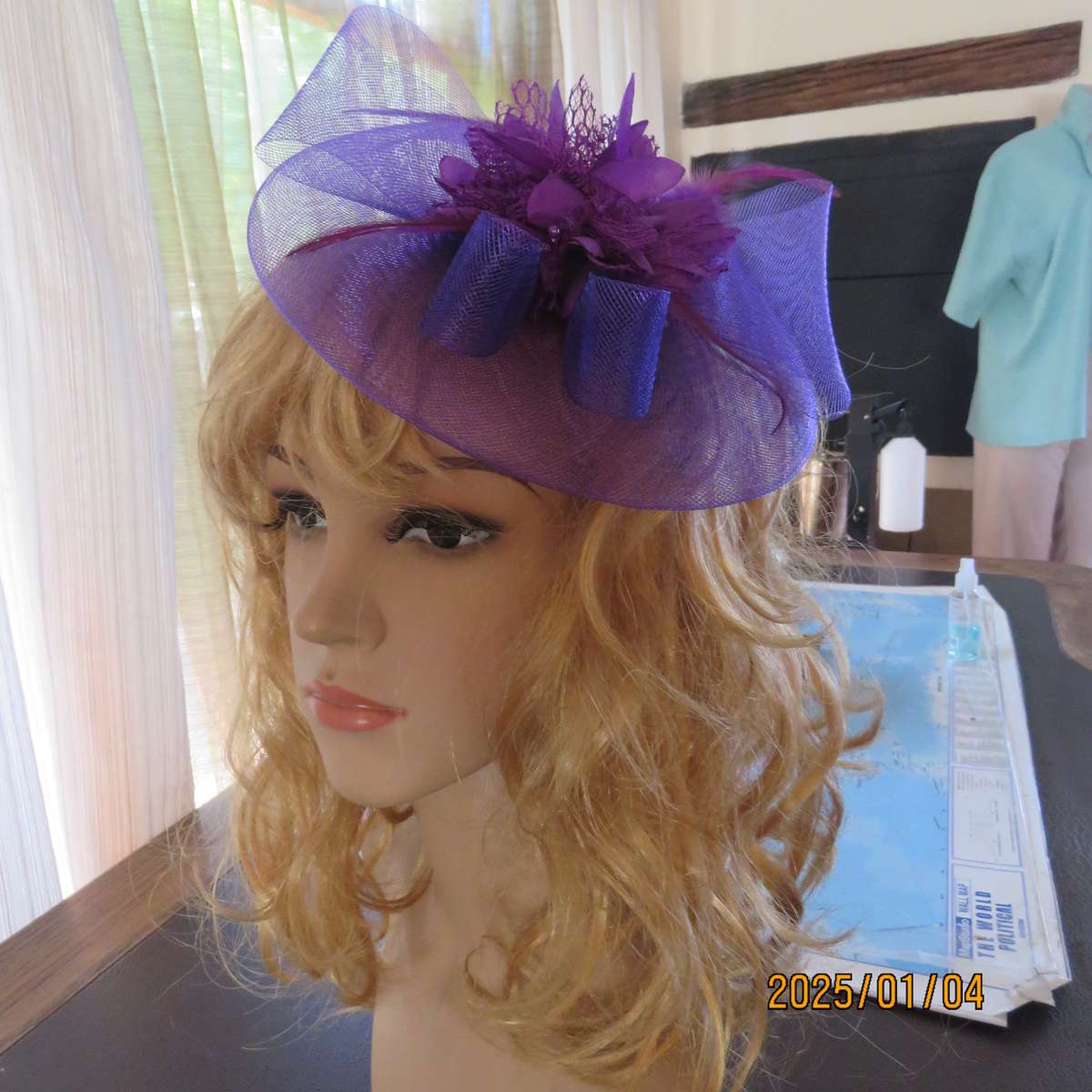 Dainty purple fascinator hat for special occasion. In mesh with bow-flower and feathers. Alice band