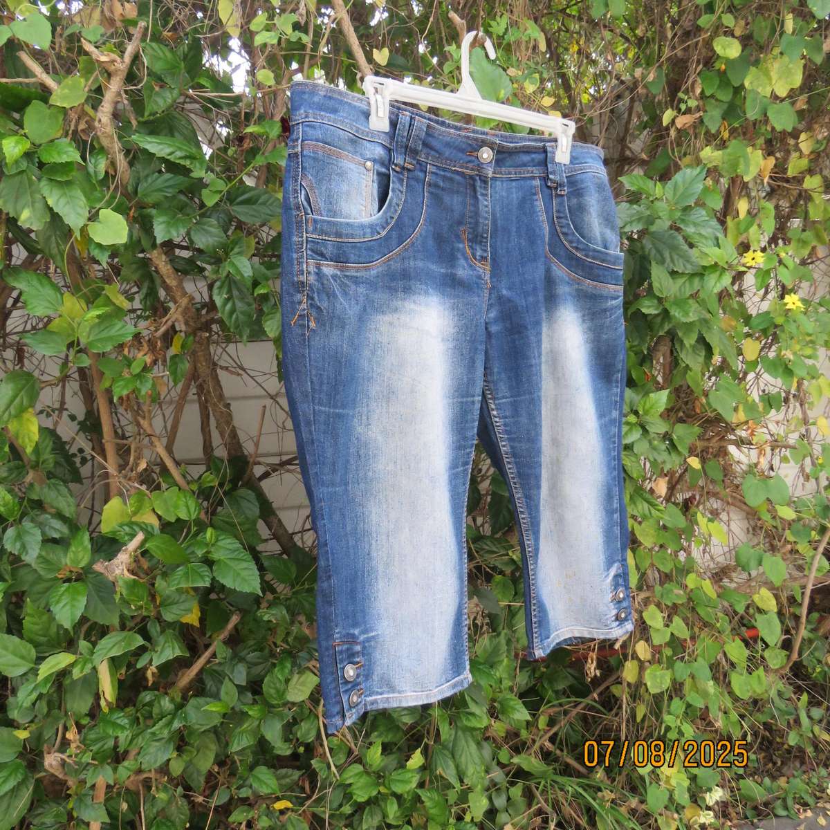 Blue denim tapered leg cropped pants size 44. Two button hem opening.