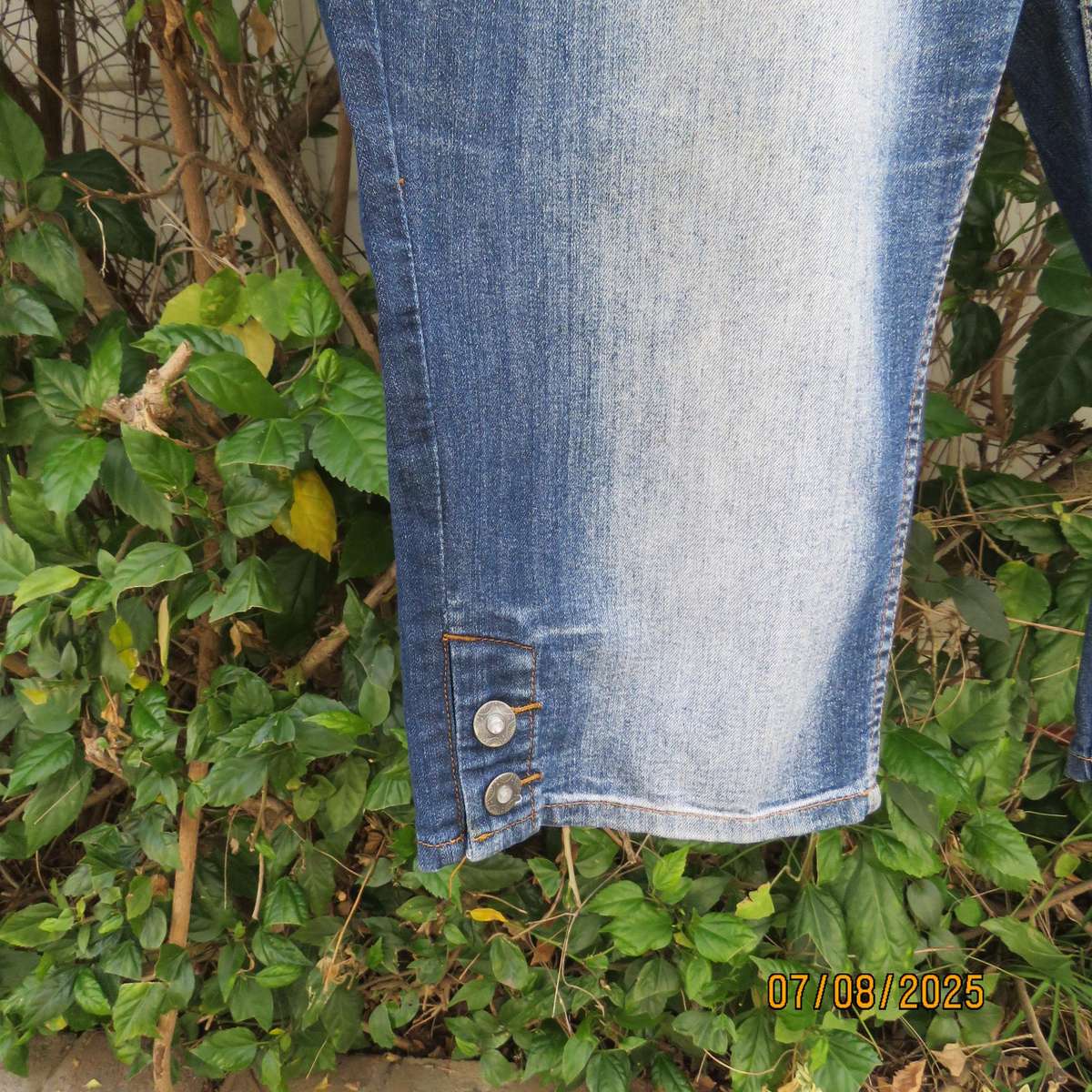 Blue denim tapered leg cropped pants size 44. Two button hem opening.