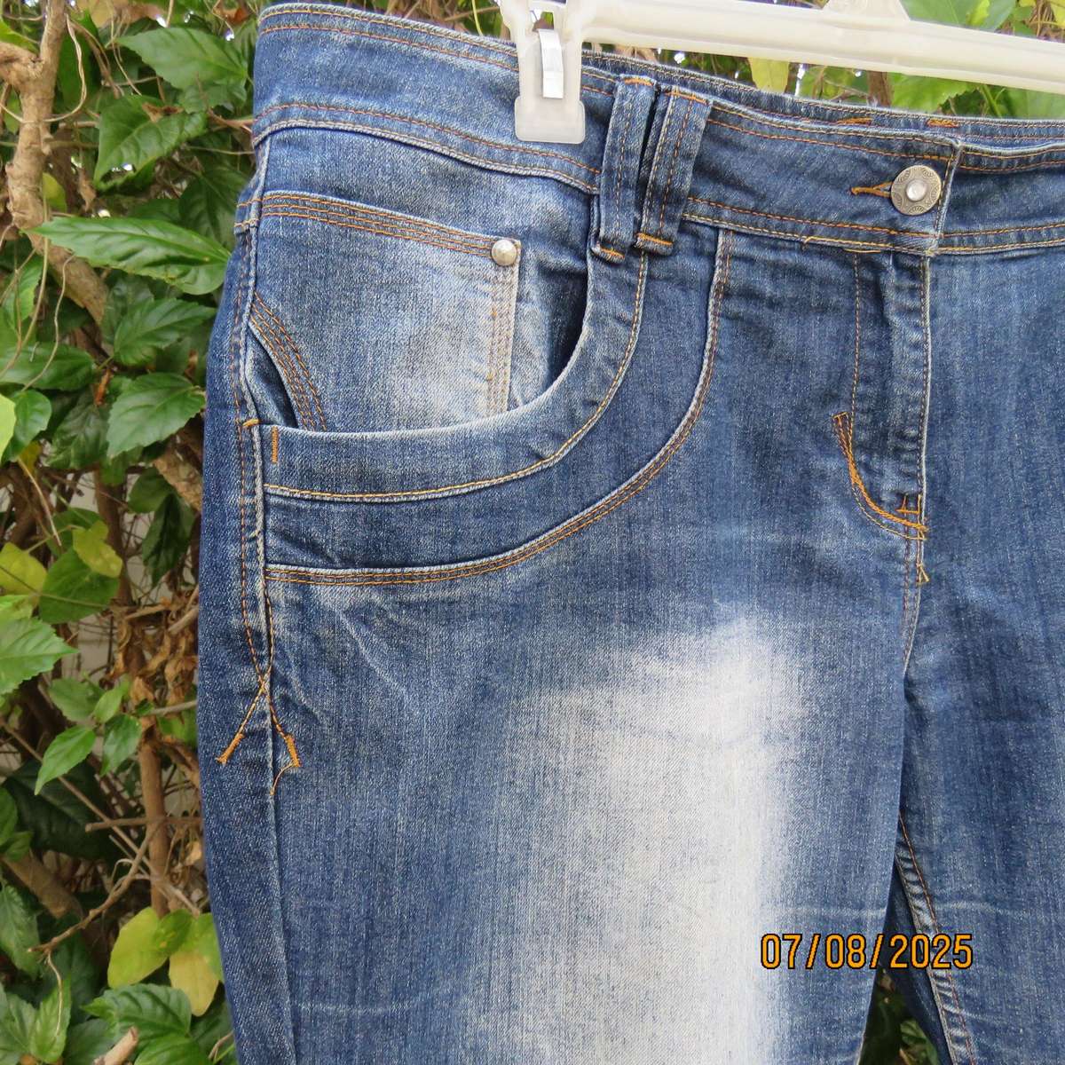 Blue denim tapered leg cropped pants size 44. Two button hem opening.