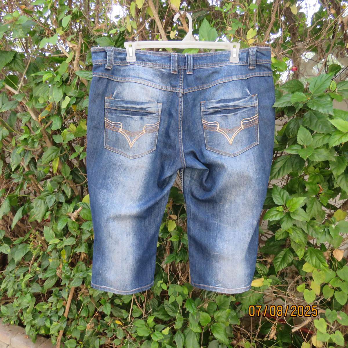 Blue denim tapered leg cropped pants size 44. Two button hem opening.