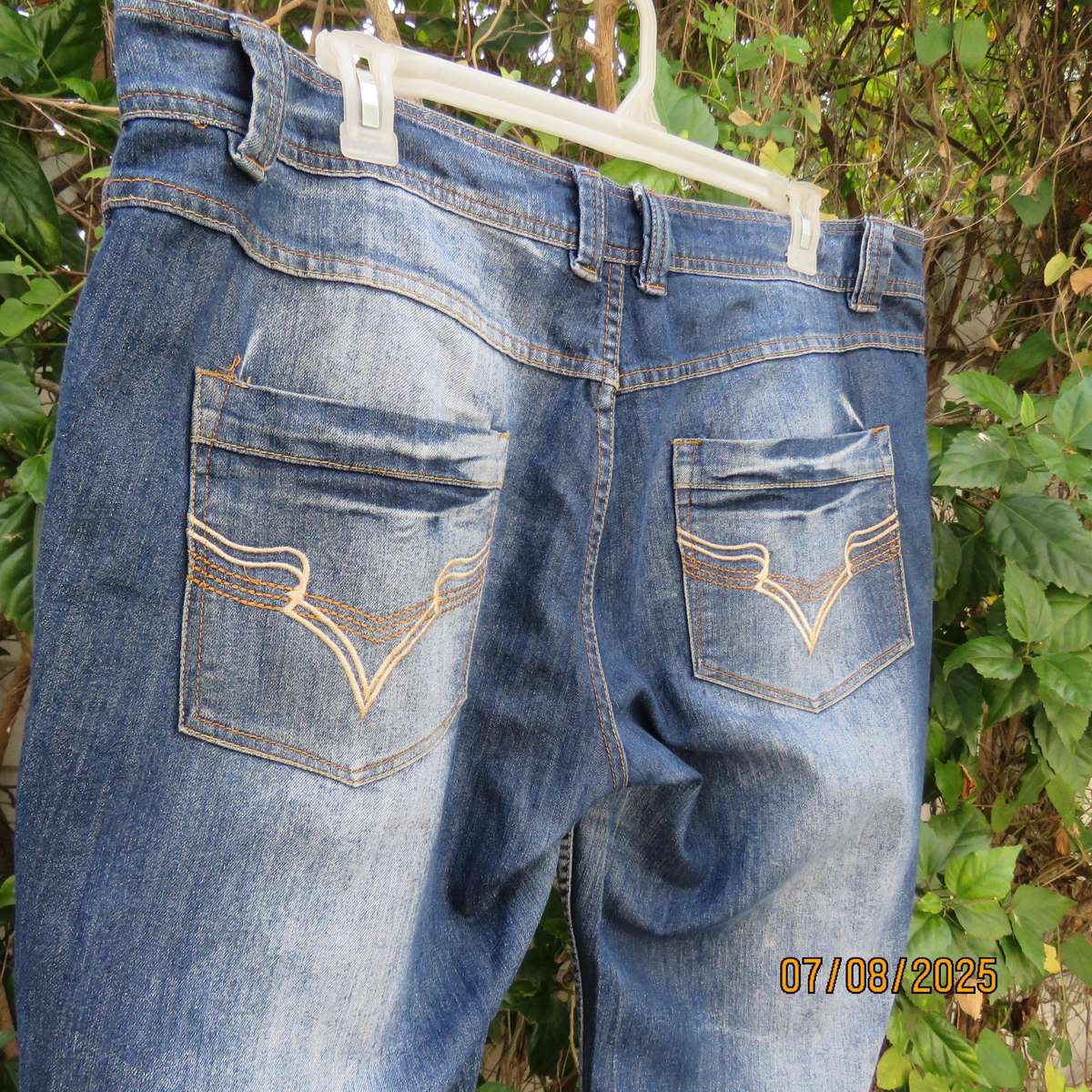 Blue denim tapered leg cropped pants size 44. Two button hem opening.