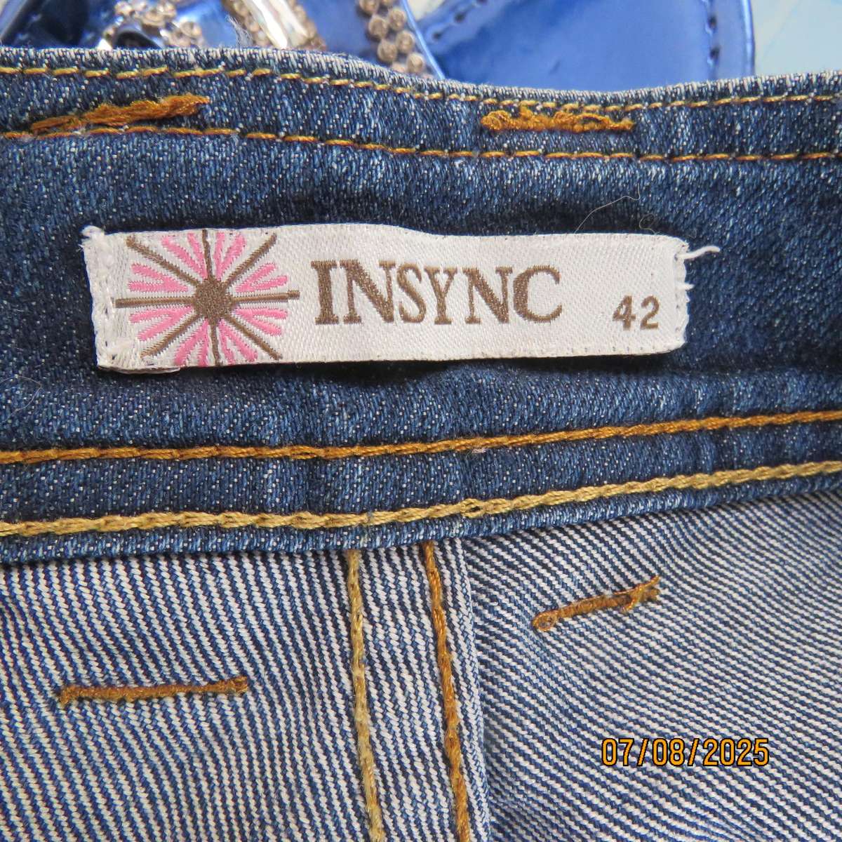 Blue denim tapered leg cropped pants size 44. Two button hem opening.