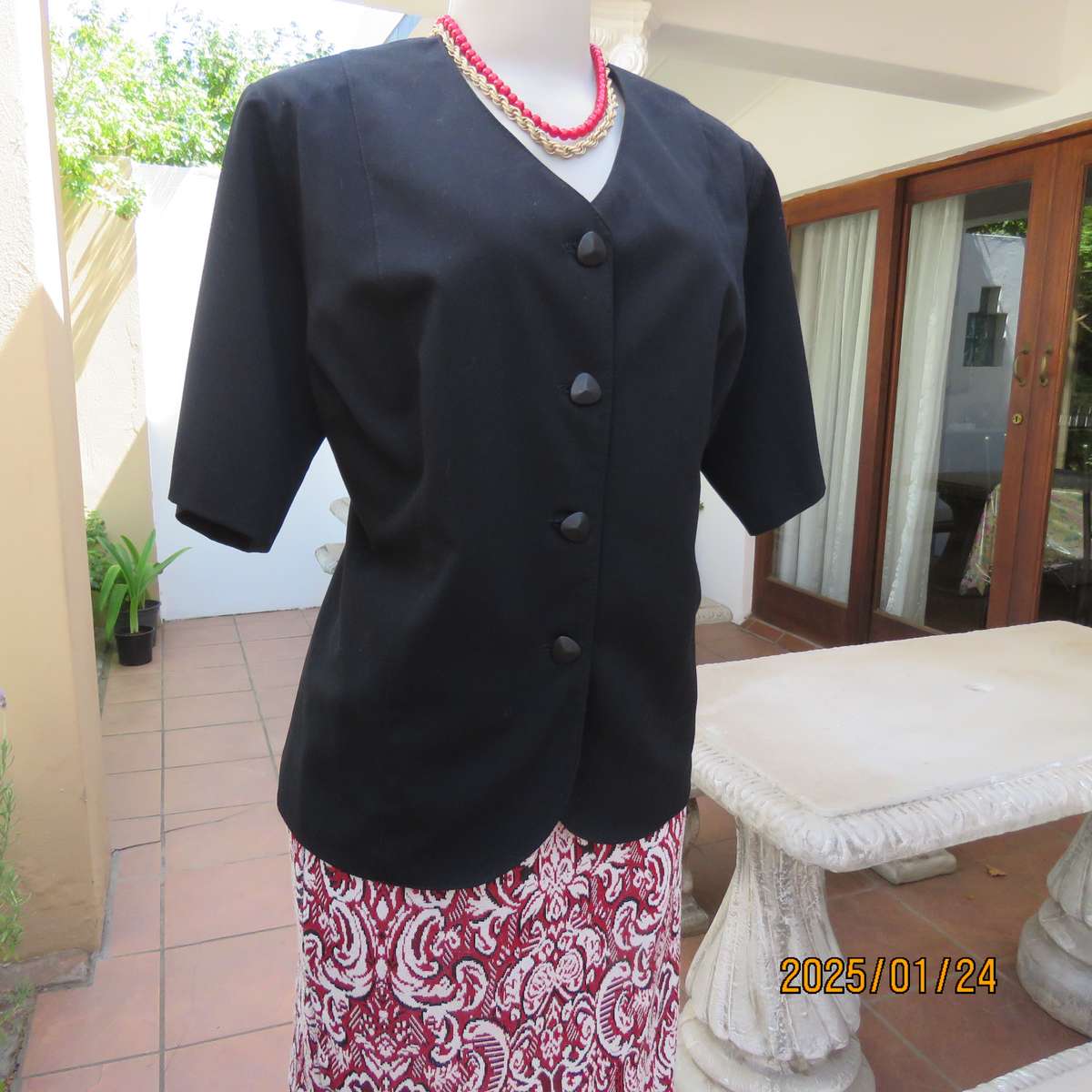 Elegant black short sleeve firm polycotton collarless jacket. Four button closure. Size 40. As new