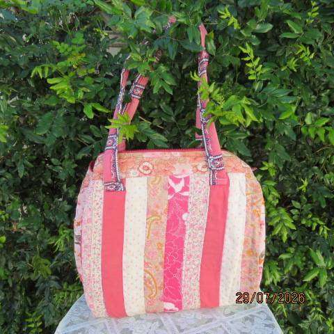 Pink patterned fabric bag with zip closure - rounded side design with straps