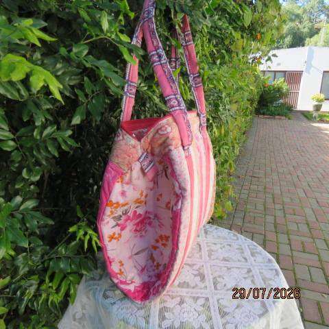 Pink patterned fabric bag with zip closure - rounded side design with straps