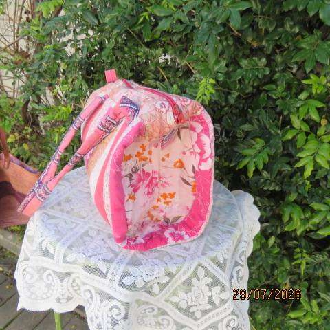 Pink patterned fabric bag with zip closure - rounded side design with straps
