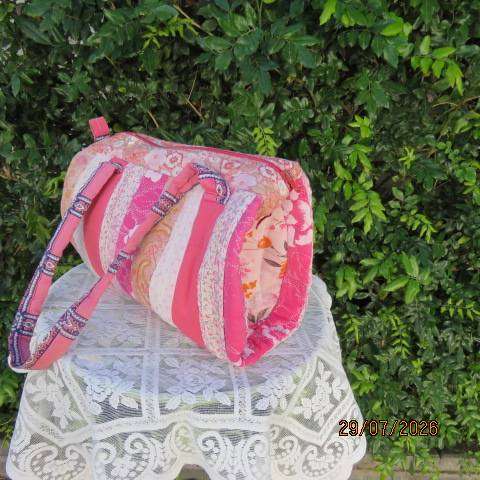 Pink patterned fabric bag with zip closure - rounded side design with straps