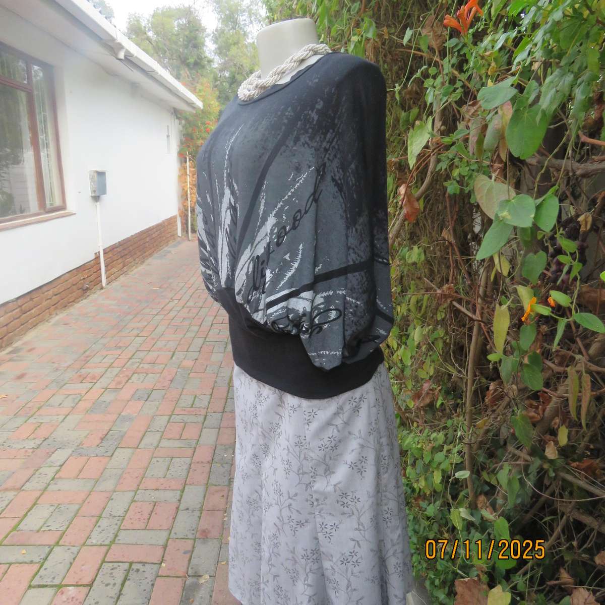 Black stretch viscose top with kimono style short sleeves. Front silver-grey print. Size 40