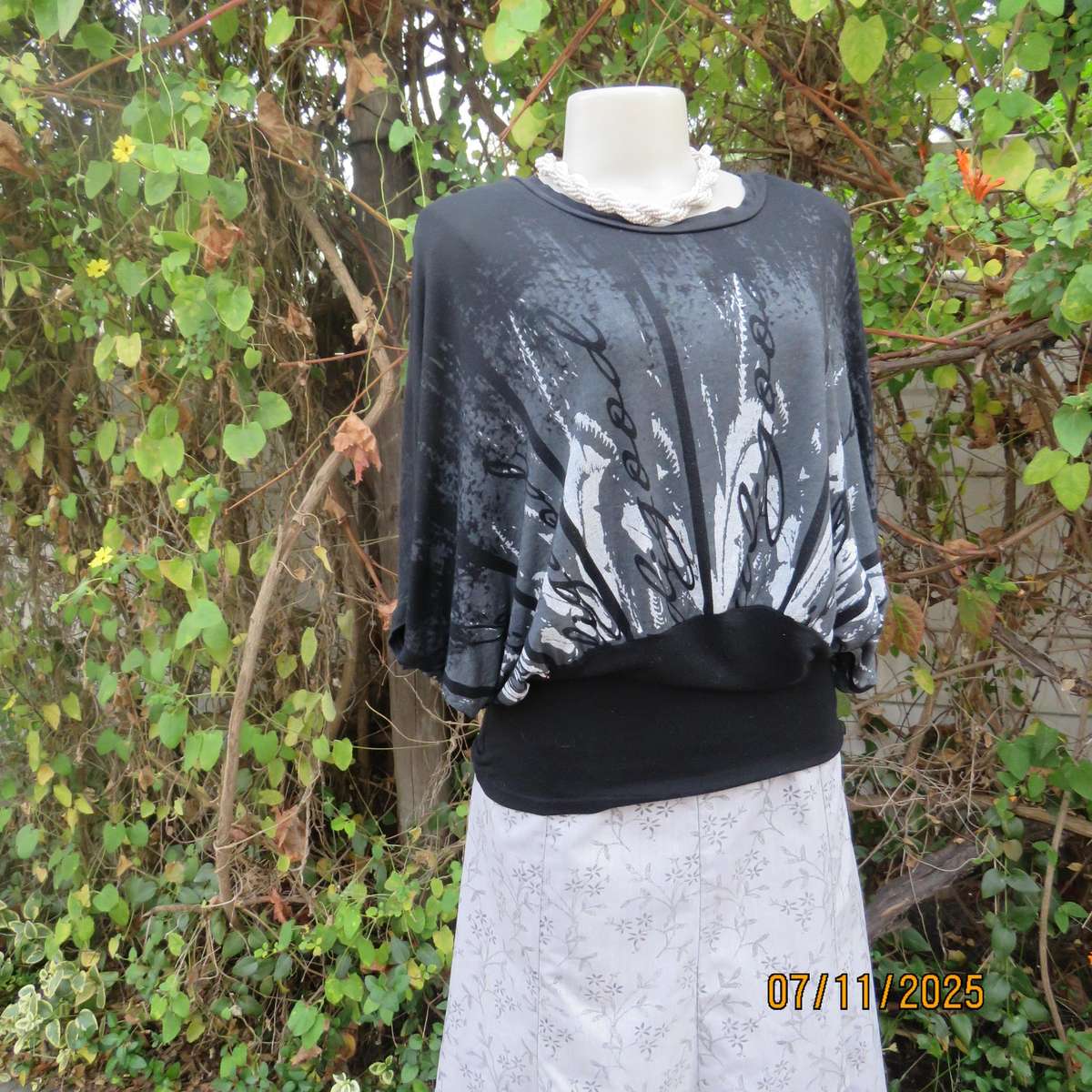 Black stretch viscose top with kimono style short sleeves. Front silver-grey print. Size 40