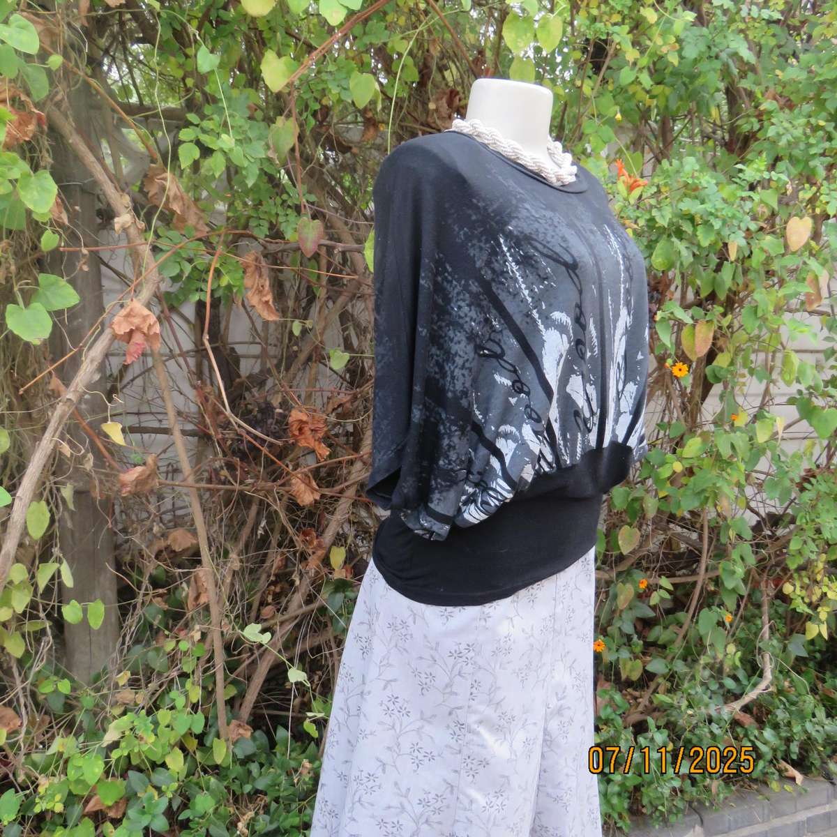 Black stretch viscose top with kimono style short sleeves. Front silver-grey print. Size 40
