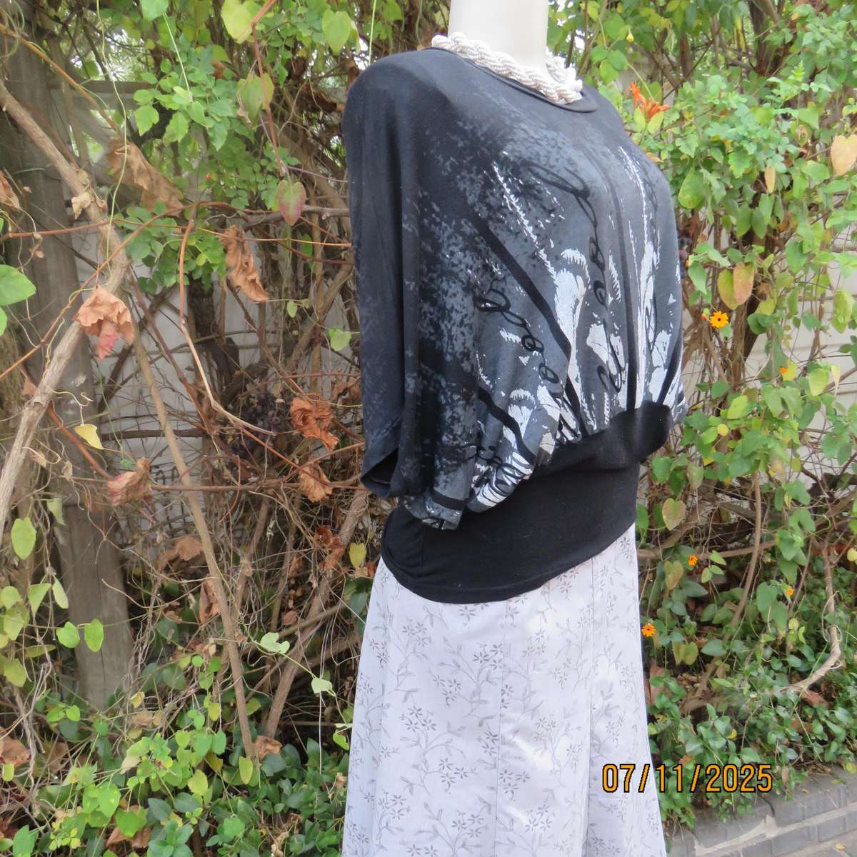 Black stretch viscose top with kimono style short sleeves. Front silver-grey print. Size 40