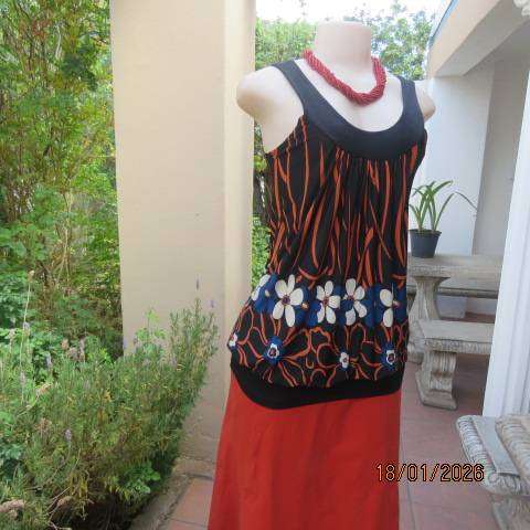 Black stretch polyester blouson style top with blue-cream-orange floral print. Wide band. Size 34
