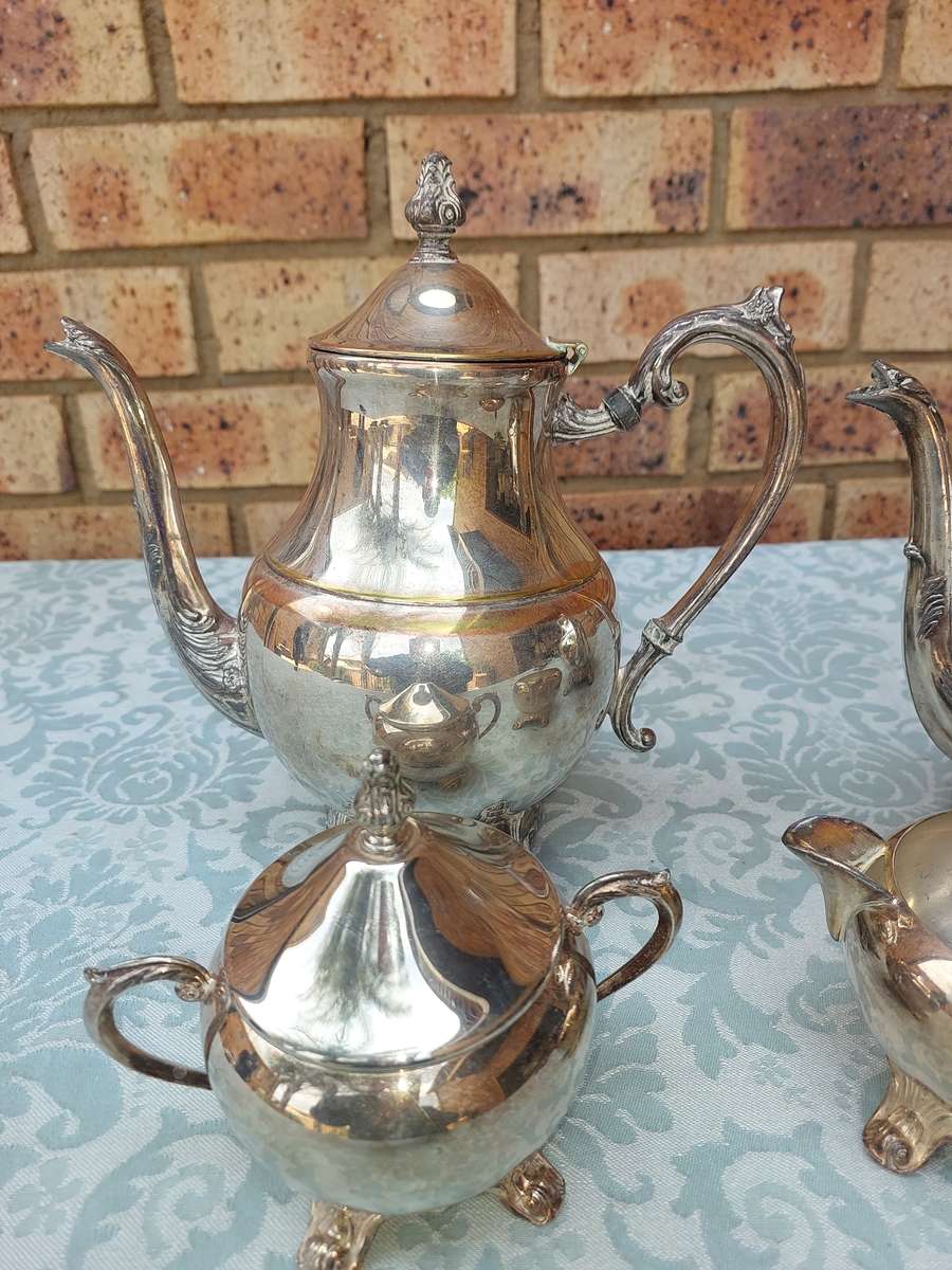 AN ANTIQUE SILVER PLATED TEA JUG SET