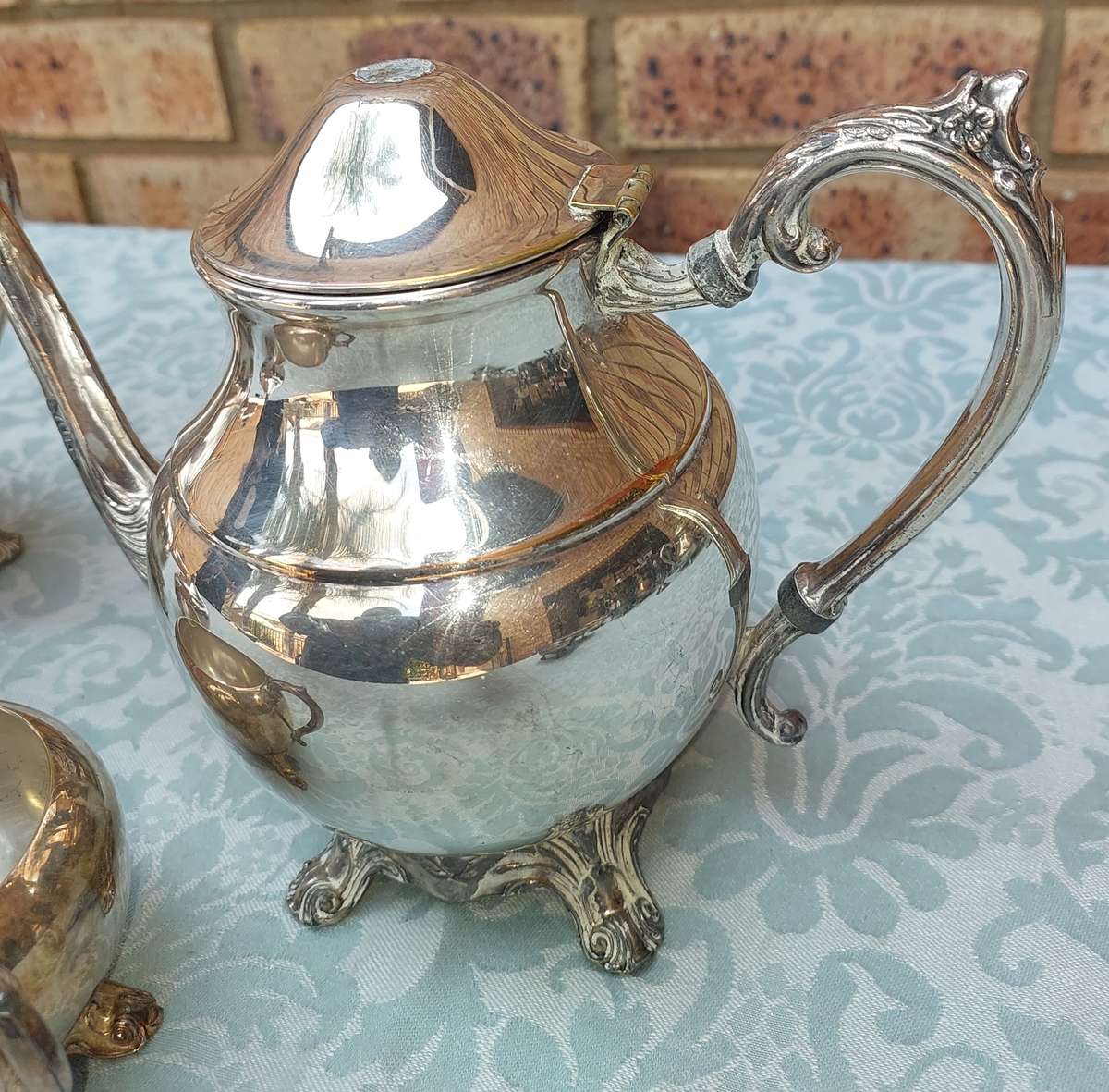 AN ANTIQUE SILVER PLATED TEA JUG SET