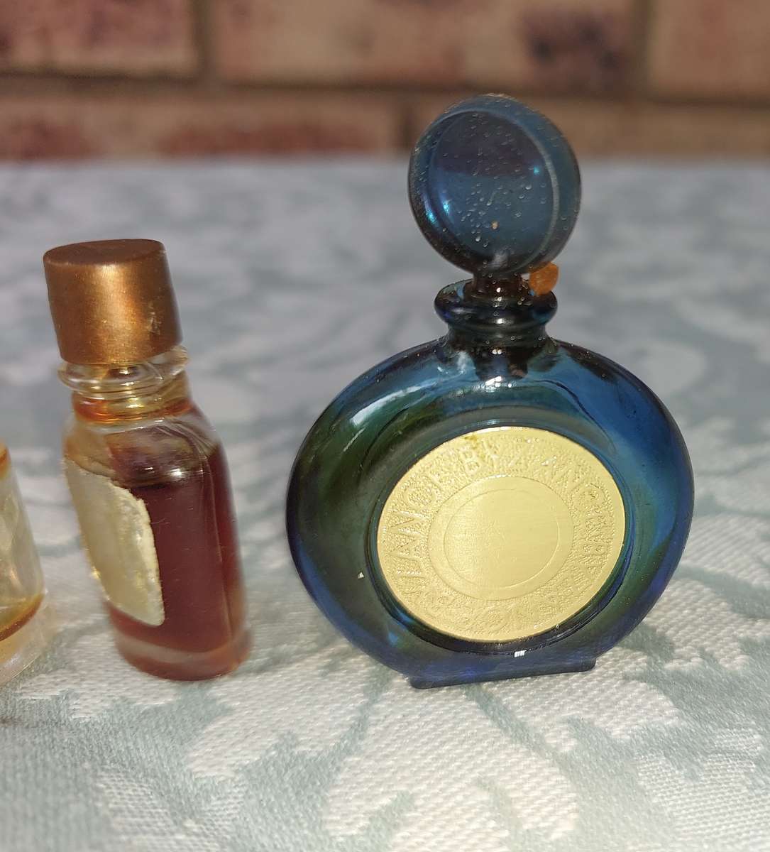 A COLLECTION OF MINITURE LALIQUE PERFUME BOTTLES AND SOME HAVE PERFUMES IN IT SOLD AS IS