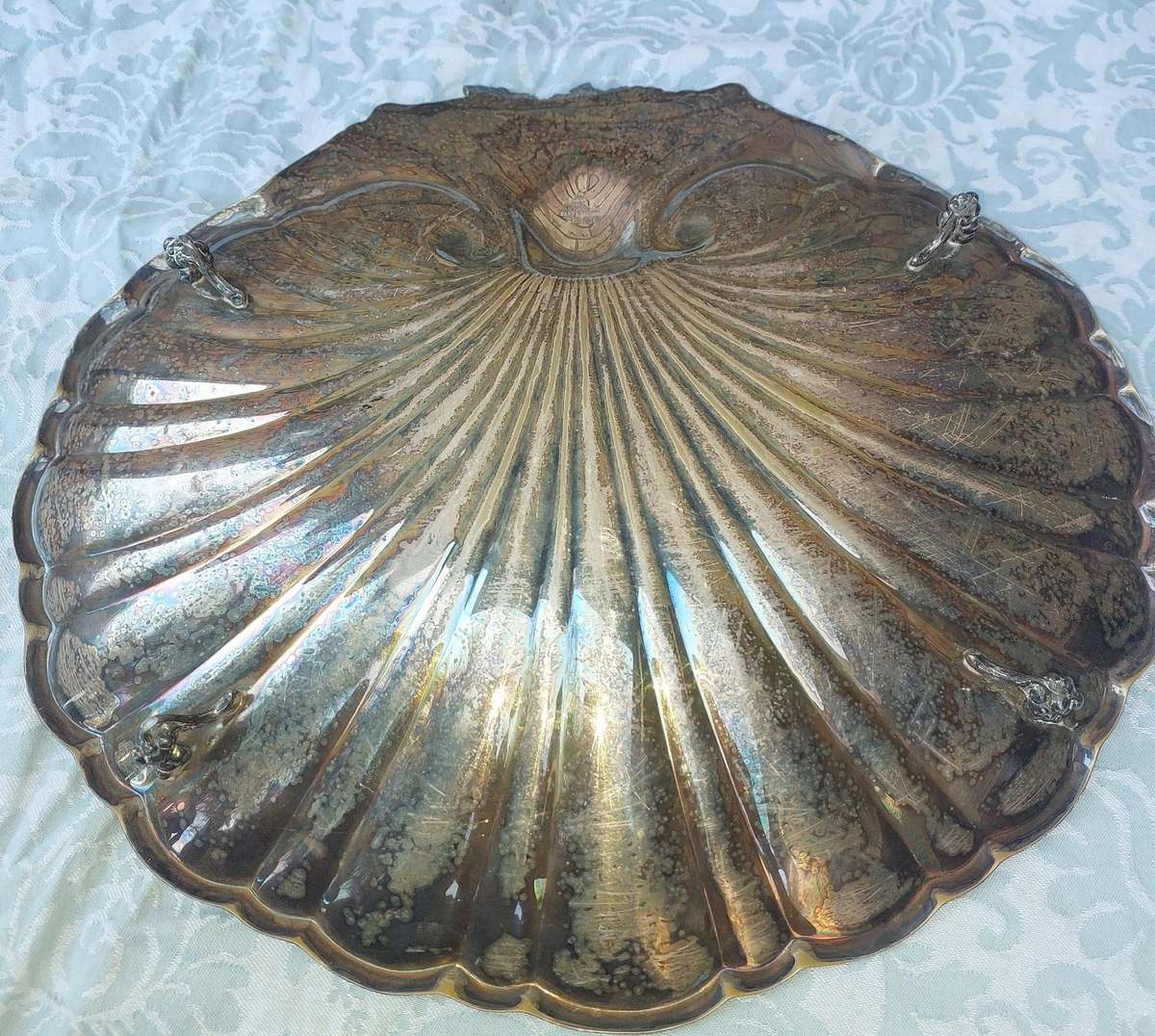 A VINTAGE SILVER PLATED SCALLOP SHELL SERVING PLATTER WITH LEGS SOLD AS IS