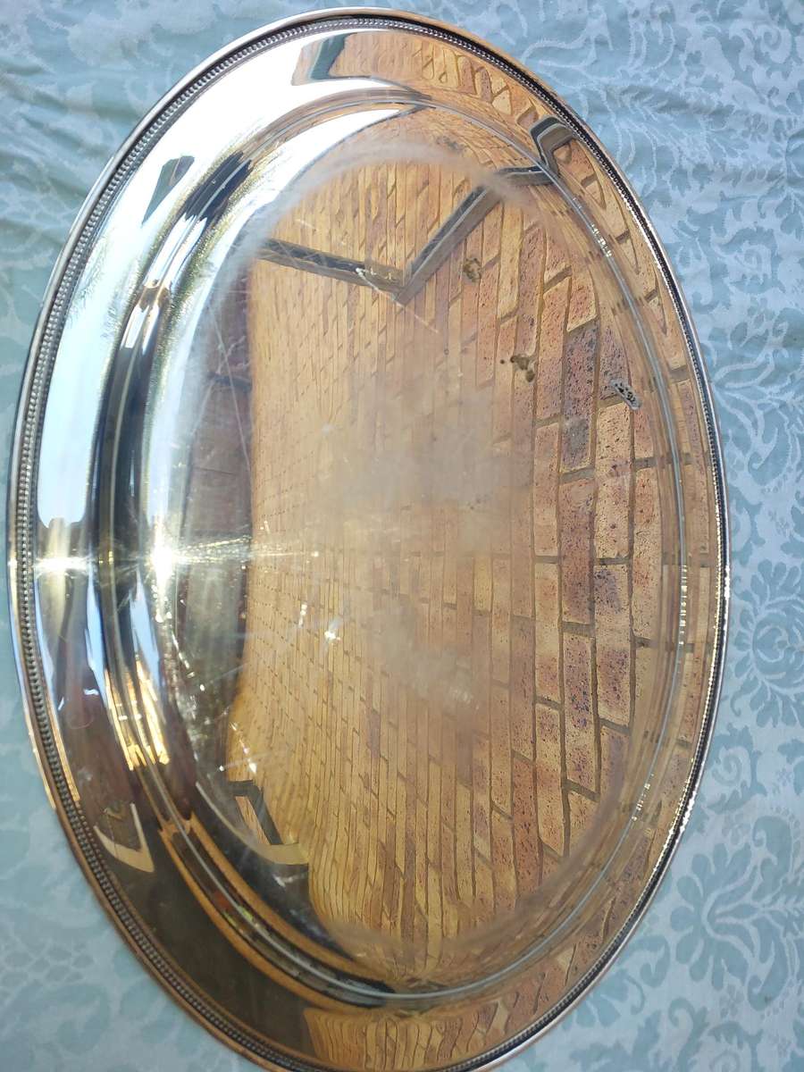 A VINTAGE SILVER PLATED OVAL SERVING TRAY SOLD AS IS