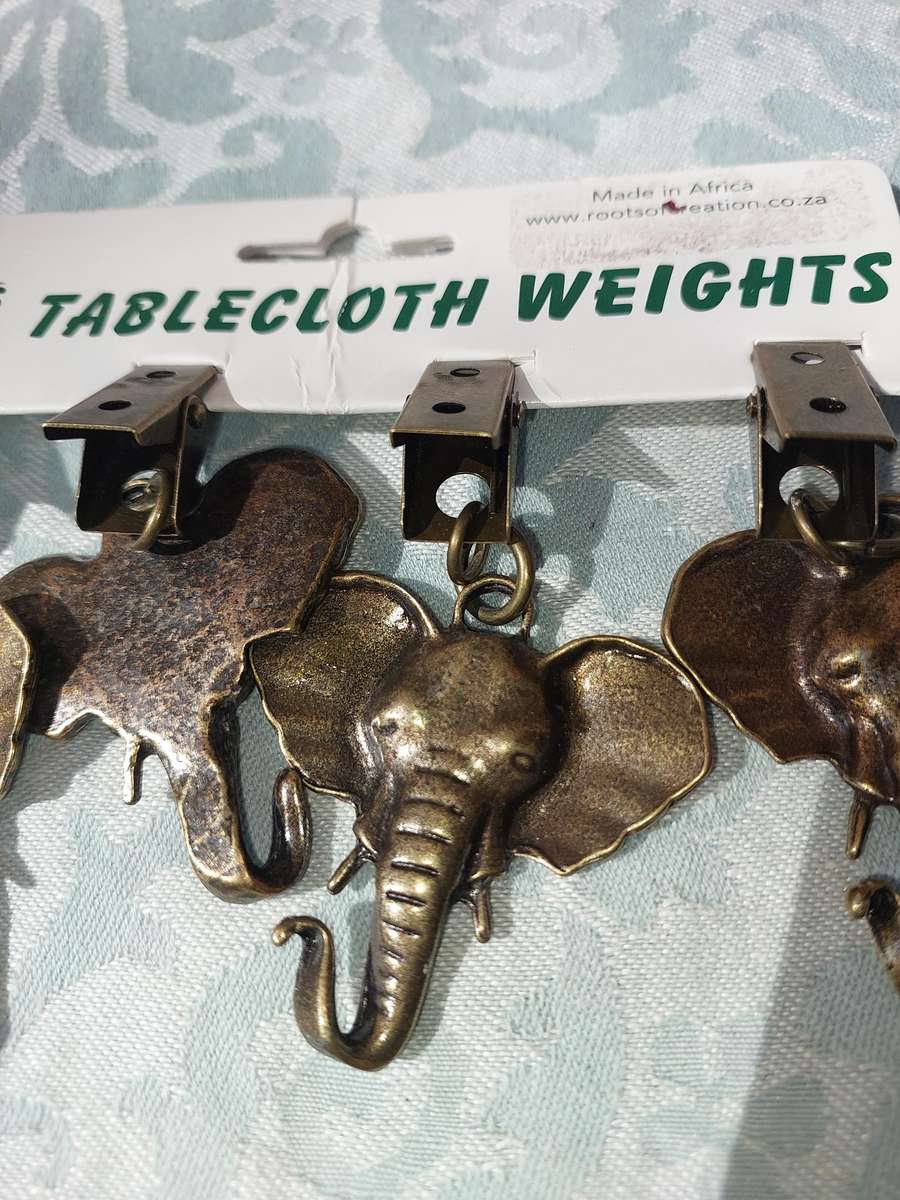 A SET OF ELEPHANT TABLE CLOTH WEIGHTS SOLD AS IS