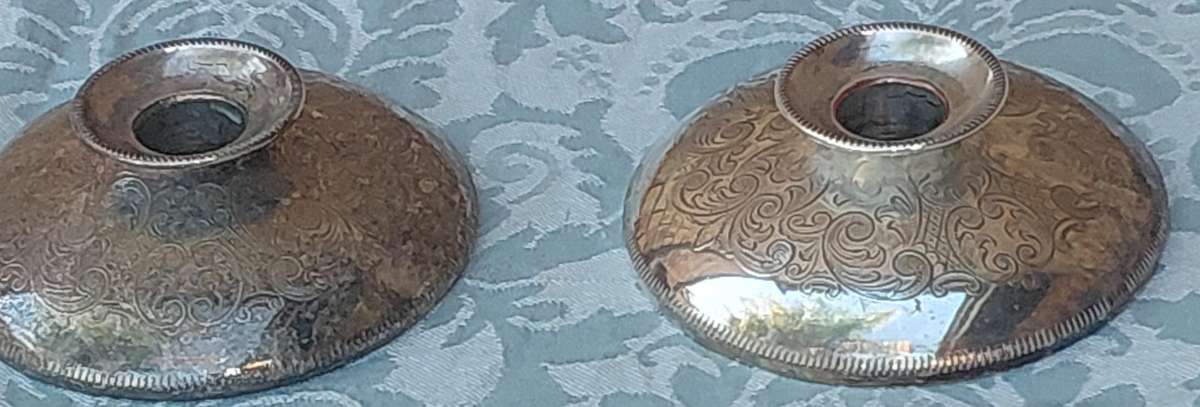 A PAIR OF SILVER PLATE ENGLAND CANDLE HOLDERS WITH ART WORK ENGRAVINGS SOLD AS IS
