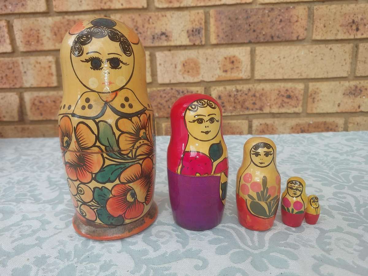 A VINTAGE SET OF FIVE RUSSIAN STACKING DOLLS SOLD AS IS