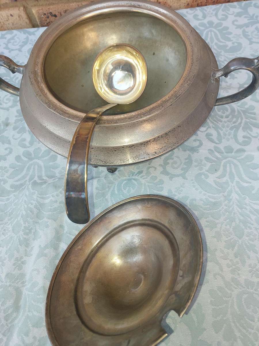 AN ANTIQUE SILVER PLATED TUREEN WITH A LADLE SOLD AS IS