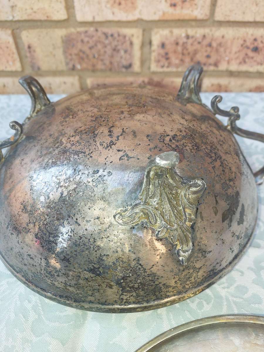 AN ANTIQUE SILVER PLATED TUREEN WITH A LADLE SOLD AS IS