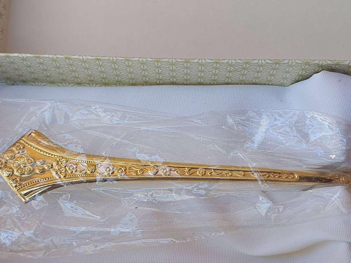 AN EETRITE 24 CARAT GOLD PLATED FLEUR CAKE CUTTER SOLD AS IS
