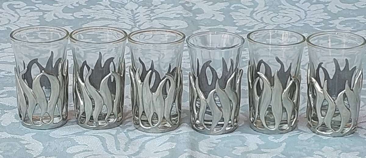 A SET OF SIX SHOT GLASSES WITH PEWTAL FALMES SOLD AS IS