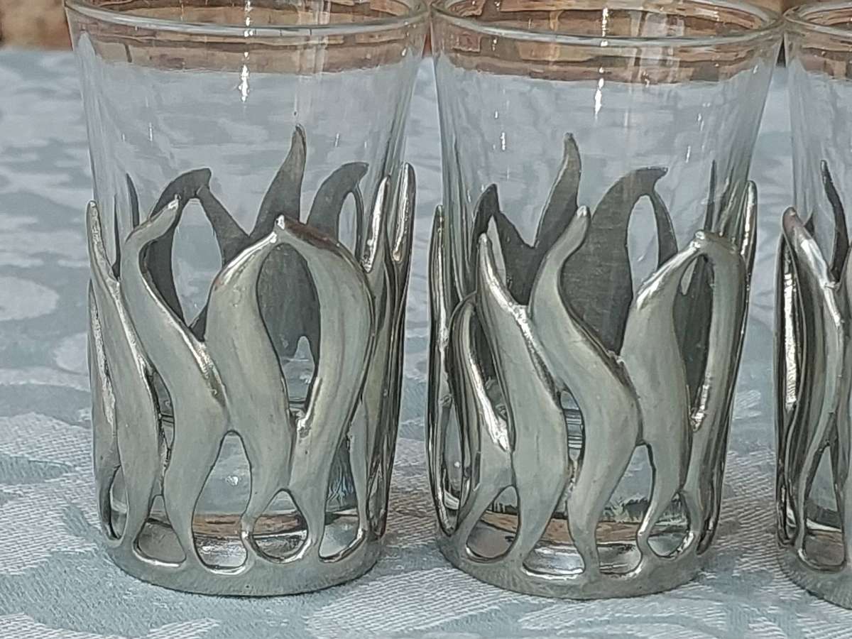 A SET OF SIX SHOT GLASSES WITH PEWTAL FALMES SOLD AS IS